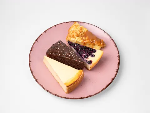 Assorted slices of cake on a pink plate