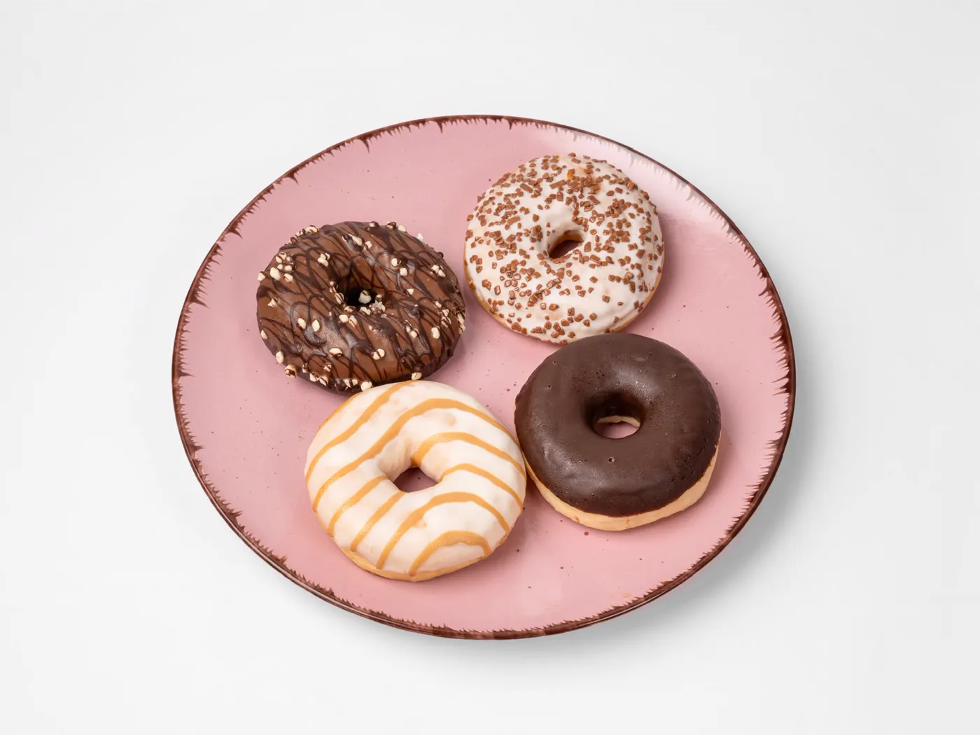 Vier verschiedene Donuts auf einem rosa Teller